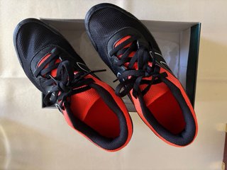 Zapatillas de clavos negras y naranjas