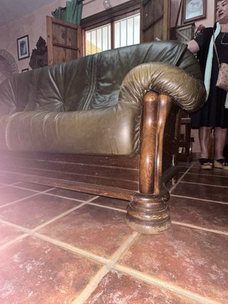 Sofá de piel verde y madera