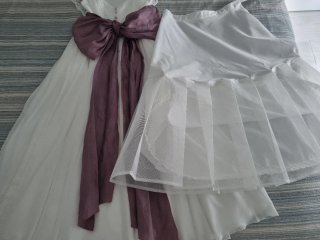 Vestido de comunión blanco con lazo morado.