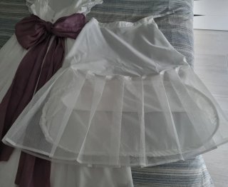 Vestido de comunión blanco con lazo morado.