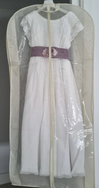 Vestido de comunión blanco con lazo morado.