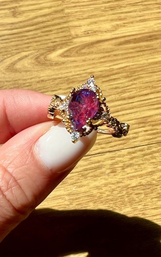 Anillo con gema morada y detalles dorados