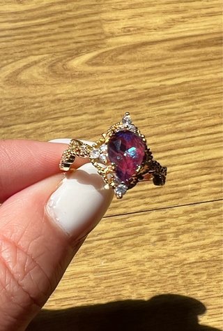 Anillo con gema morada y detalles dorados