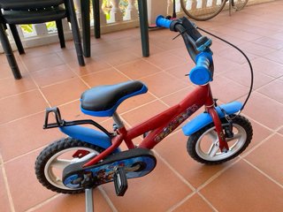 Bicicleta infantil roja con ruedines