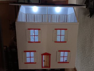 Casa de muñecas con ventanas naranjas