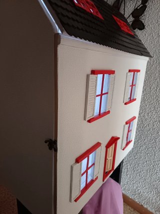 Casa de muñecas con ventanas naranjas