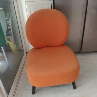 Sillón naranja de tela y alfombra