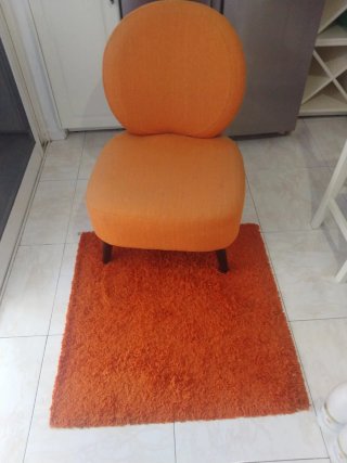 Sillón naranja de tela y alfombra