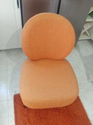 Sillón naranja de tela y alfombra