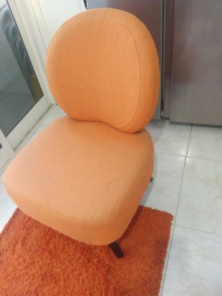 Sillón naranja de tela y alfombra