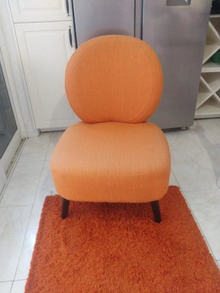 Sillón naranja de tela y alfombra