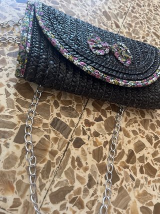 Bolso de mano negro con lazo floral