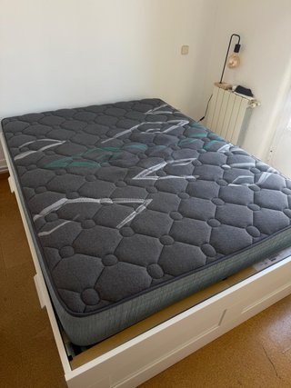 Colchón de cama gris con diseño.