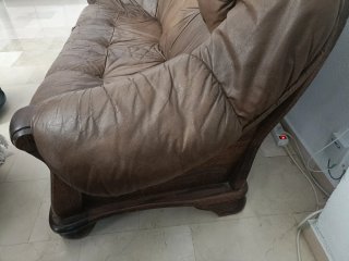 Sofá de piel marrón con detalles de madera
