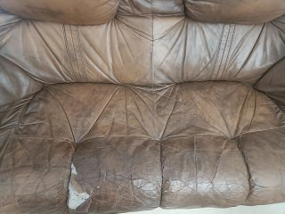 Sofá de piel marrón con detalles de madera