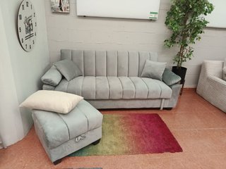 Sofá cama gris con arcón y puff