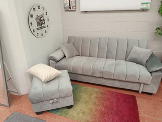 Sofá cama gris con arcón y puff