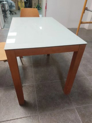 Mesa de cristal y dos sillas de madera y metal.
