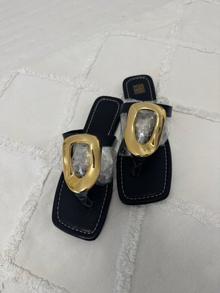 Sandalias planas negras con detalle dorado