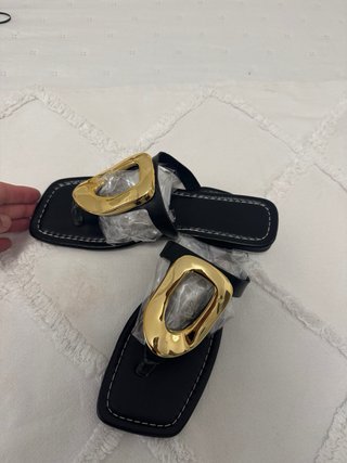 Sandalias planas negras con detalle dorado