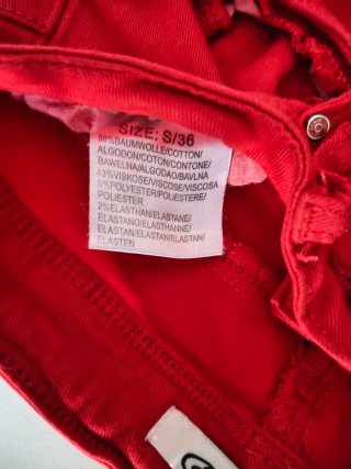 Pantalón pitillo rojo con aberturas desgastada