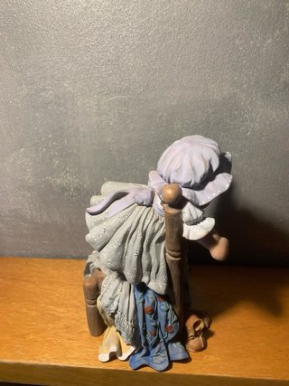 Muñeca Cuqui sentada en silla de madera