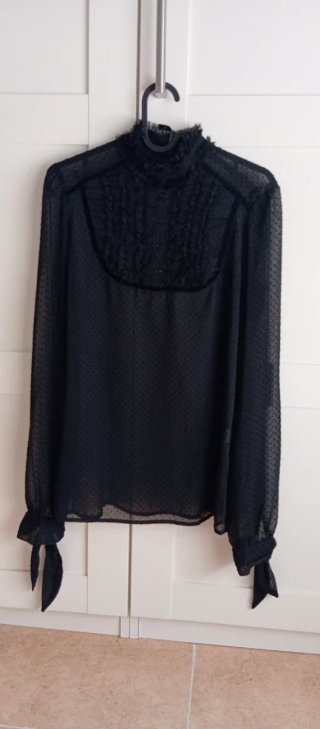 Blusa negra con volantes y lazada