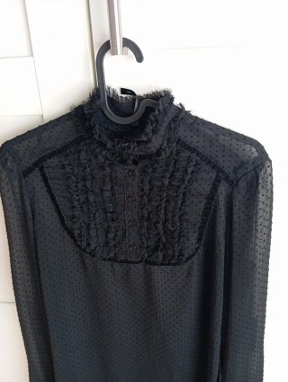Blusa negra con volantes y lazada