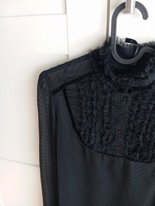 Blusa negra con volantes y lazada
