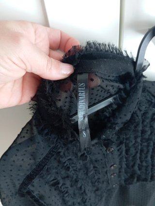 Blusa negra con volantes y lazada