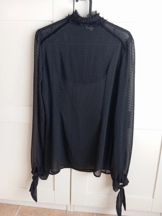 Blusa negra con volantes y lazada