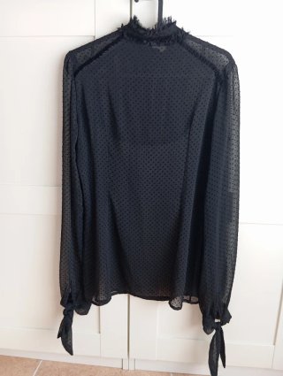 Blusa negra con volantes y lazada