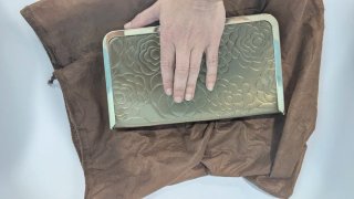 Bolso de fiesta dorado con flores en relieve