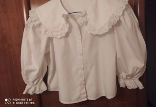 Blusa blanca con cuello volante y encaje