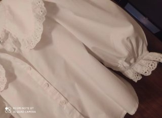 Blusa blanca con cuello volante y encaje