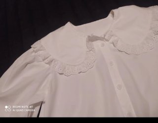 Blusa blanca con cuello volante y encaje