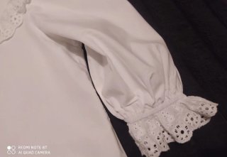 Blusa blanca con cuello volante y encaje