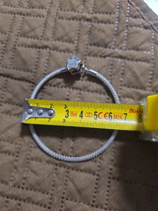 Pulsera Pandora con charm de flor en plata.