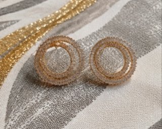 Brincos dourados em espiral com pedras brilhantes