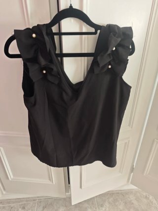 Blusa negra con volantes y perlas