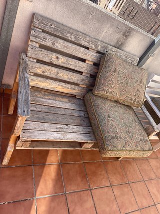 Banco de terraza de madera con cojines.