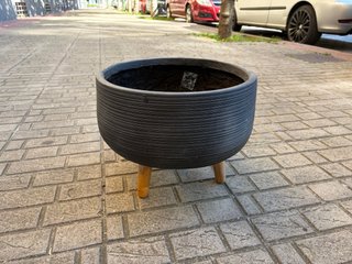 Macetero negro con patas de madera
