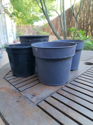 4 macetas negras de plástico