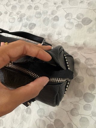 Bolso negro tipo baúl con tachuelas