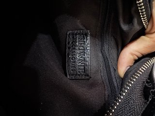 Bolso negro tipo baúl con tachuelas