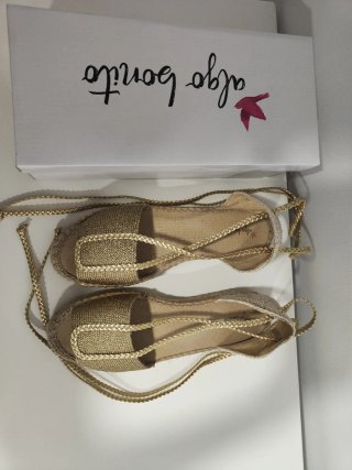 Sandalias doradas con cordones.