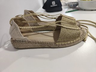 Sandalias doradas con cordones.