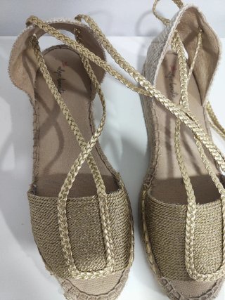 Sandalias doradas con cordones.