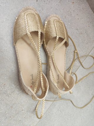 Sandalias doradas con cordones.