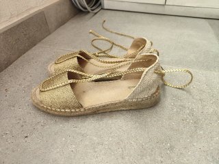 Sandalias doradas con cordones.